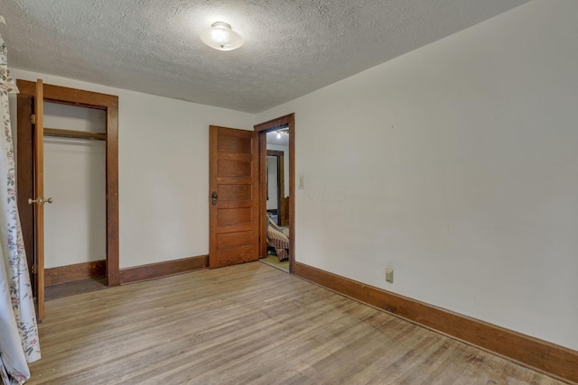 6135 Westfall Rd SW, Lancaster, OH 43130 - unfurnished bedroom featuring light wood-style floors, a closet, and a textured ceiling
