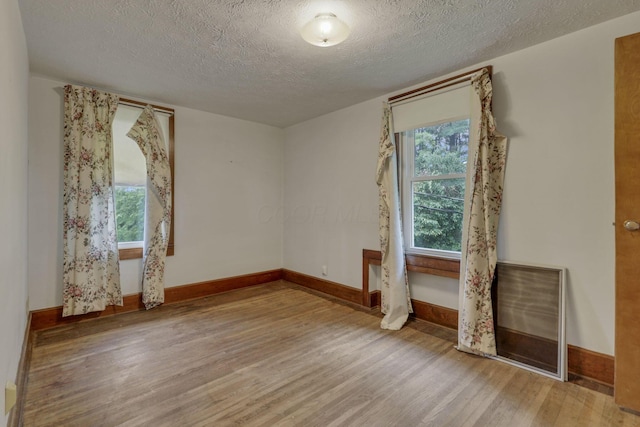 6135 Westfall Rd SW, Lancaster, OH 43130 - unfurnished room with wood finished floors, healthy amount of natural light, and a textured ceiling