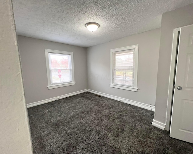 1116-1122 Cole St, Columbus, OH 43205 - empty room with dark colored carpet, healthy amount of natural light, and a textured ceiling