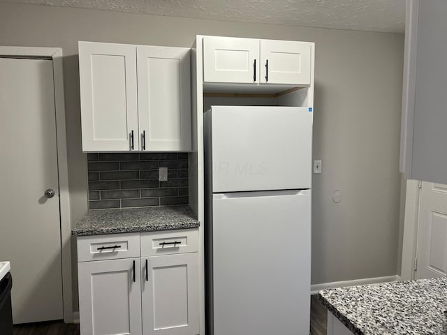 1116-1122 Cole St, Columbus, OH 43205 - kitchen featuring freestanding refrigerator, dark stone counters, backsplash, white cabinetry, and a textured ceiling