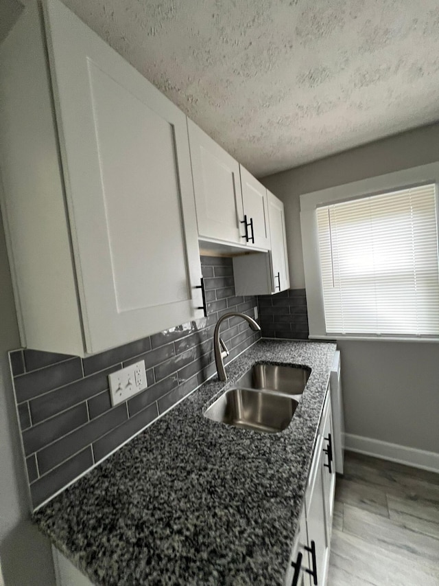 1116-1122 Cole St, Columbus, OH 43205 - kitchen with white cabinets, a textured ceiling, light wood-style floors, decorative backsplash, and dark stone counters