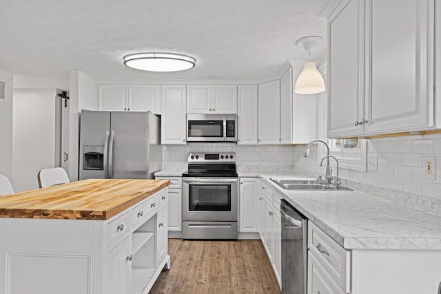 4400 Yellowhammer Dr, Westerville, OH 43081 - kitchen with stainless steel appliances, butcher block counters, white cabinets, a center island, and wood finished floors