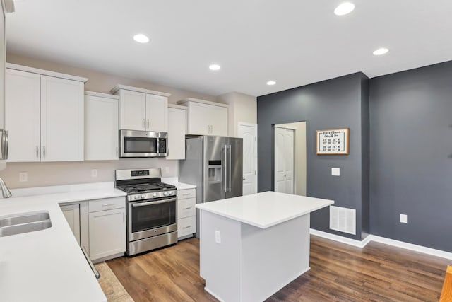 3987 Mad River Rd, Grove City, OH 43123 - kitchen with appliances with stainless steel finishes, a kitchen island, dark wood-style floors, light countertops, and white cabinetry