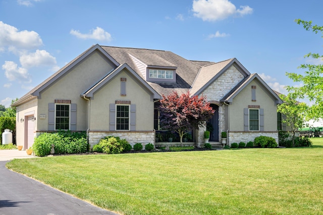 8150 Concord Rd, Delaware, OH 43015 - view of front facade with stone siding, stucco siding, an attached garage, and a front yard