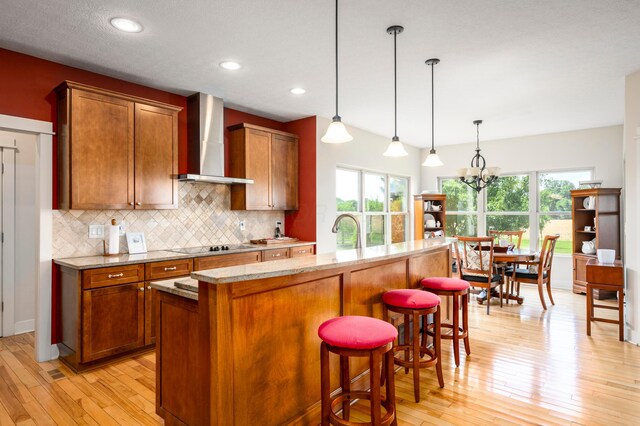 8150 Concord Rd, Delaware, OH 43015 - kitchen featuring wall chimney range hood, light wood finished floors, backsplash, plenty of natural light, and recessed lighting