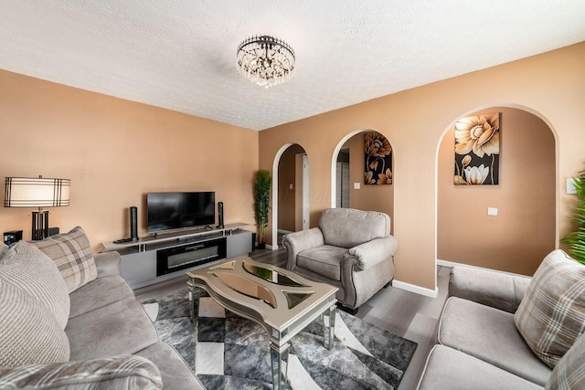 1914 Walden Dr, Columbus, OH 43229 - living area with arched walkways, wood finished floors, and a textured ceiling