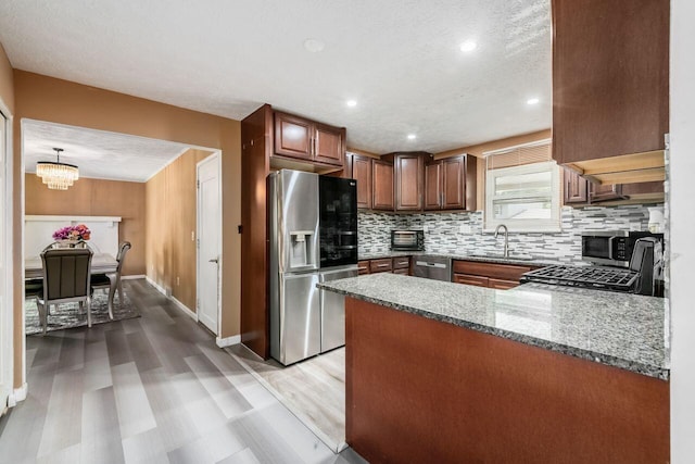 1914 Walden Dr, Columbus, OH 43229 - kitchen with appliances with stainless steel finishes, tasteful backsplash, light wood finished floors, a peninsula, and light stone countertops