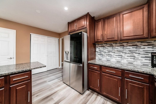 1914 Walden Dr, Columbus, OH 43229 - kitchen with stainless steel fridge with ice dispenser, light wood-type flooring, backsplash, light stone countertops, and a textured ceiling