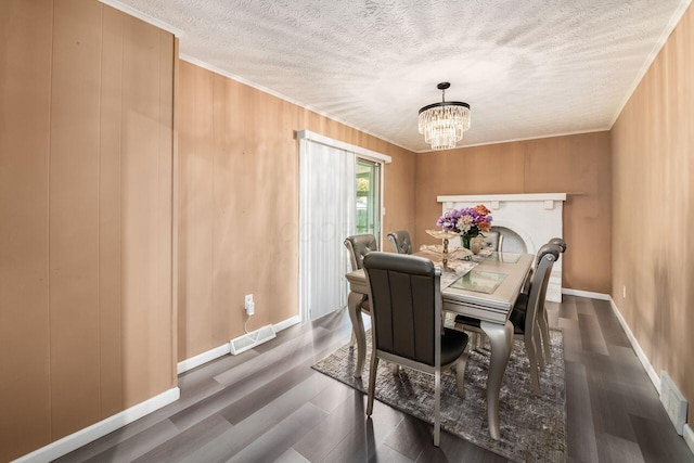 1914 Walden Dr, Columbus, OH 43229 - dining room featuring a chandelier, a textured ceiling, ornamental molding, wood finished floors, and wooden walls