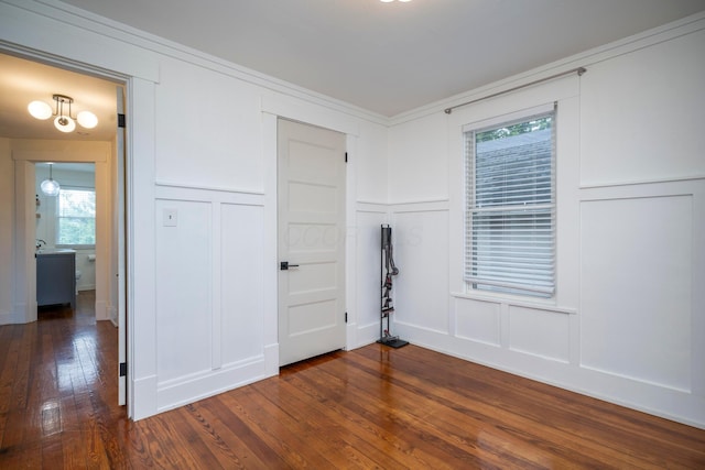 619 Columbus Ave, Washington Court House, OH 43160 - unfurnished bedroom featuring a decorative wall, multiple windows, dark wood-type flooring, and a closet
