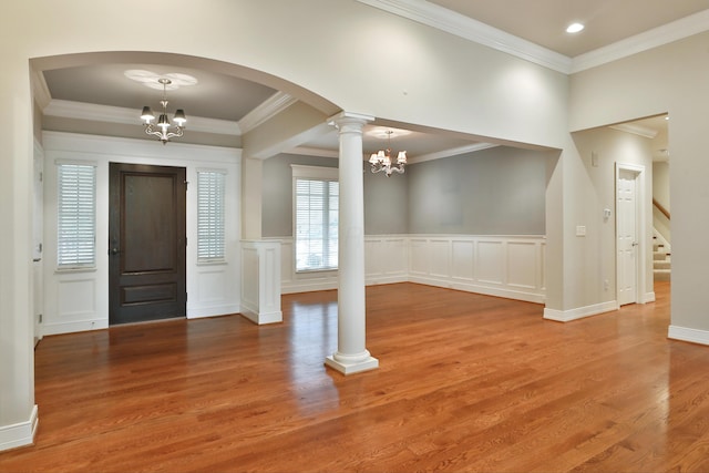 580 Keyes Ln, Worthington, OH 43085 - foyer featuring a chandelier, wood finished floors, decorative columns, a decorative wall, and crown molding
