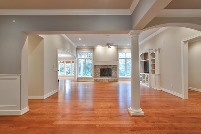 580 Keyes Ln, Worthington, OH 43085 - unfurnished living room with a ceiling fan, crown molding, a fireplace, light wood-style floors, and arched walkways