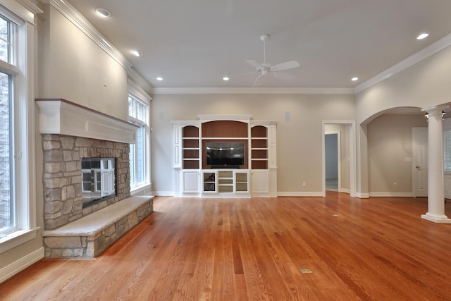 580 Keyes Ln, Worthington, OH 43085 - unfurnished living room featuring ceiling fan, a fireplace, light wood finished floors, ornamental molding, and arched walkways