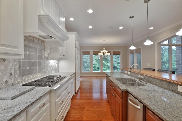 580 Keyes Ln, Worthington, OH 43085 - kitchen featuring appliances with stainless steel finishes, crown molding, decorative backsplash, light wood-style floors, and premium range hood
