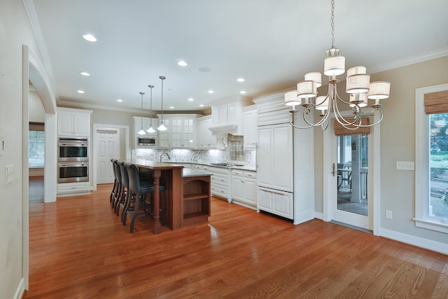 580 Keyes Ln, Worthington, OH 43085 - kitchen with appliances with stainless steel finishes, a chandelier, tasteful backsplash, crown molding, and white cabinetry