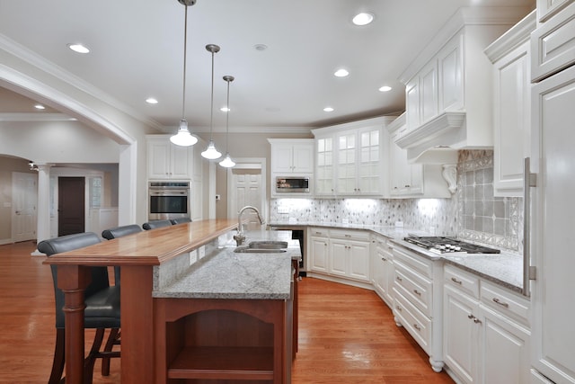 580 Keyes Ln, Worthington, OH 43085 - kitchen with appliances with stainless steel finishes, decorative columns, a breakfast bar, white cabinetry, and recessed lighting