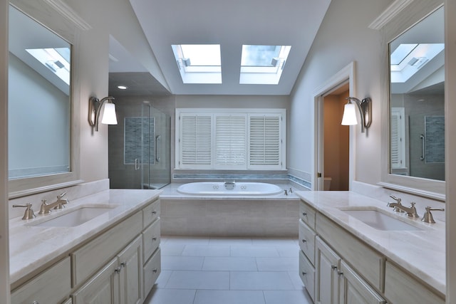 580 Keyes Ln, Worthington, OH 43085 - bathroom featuring a skylight, a stall shower, two vanities, vaulted ceiling, and a garden tub
