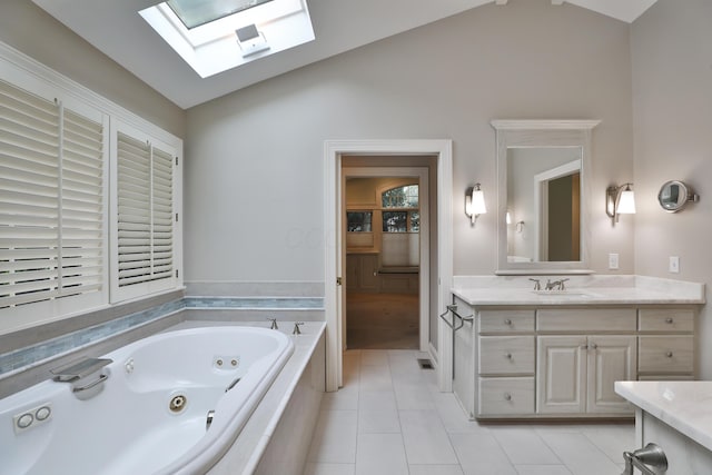 580 Keyes Ln, Worthington, OH 43085 - bathroom featuring a skylight, lofted ceiling, a tub with jets, vanity, and tile patterned floors