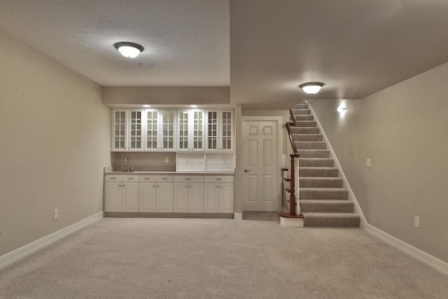580 Keyes Ln, Worthington, OH 43085 - finished below grade area featuring light colored carpet, stairway, wet bar, and a textured ceiling
