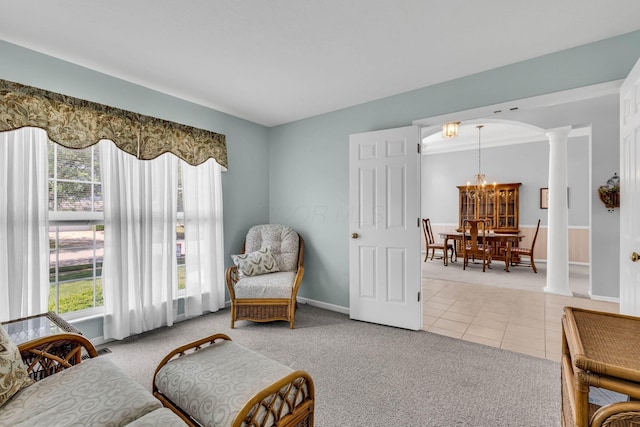 180 Locust Curve Dr, Delaware, OH 43015 - living area with ornate columns, light tile patterned flooring, light carpet, a chandelier, and arched walkways