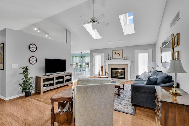 180 Locust Curve Dr, Delaware, OH 43015 - living room with a skylight, a ceiling fan, light wood-type flooring, a fireplace, and high vaulted ceiling