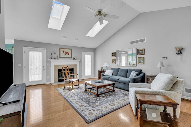 180 Locust Curve Dr, Delaware, OH 43015 - living area featuring a skylight, a ceiling fan, plenty of natural light, high vaulted ceiling, and a tiled fireplace
