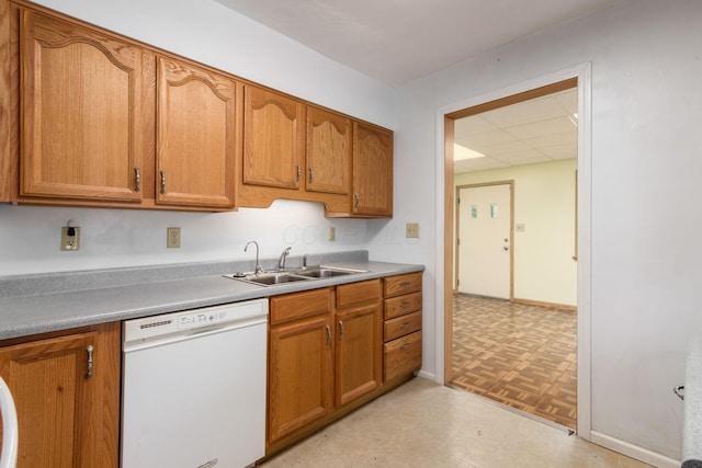 2969 Grasmere Ave, Columbus, OH 43224 - kitchen featuring white dishwasher, brown cabinets, light countertops, and a paneled ceiling