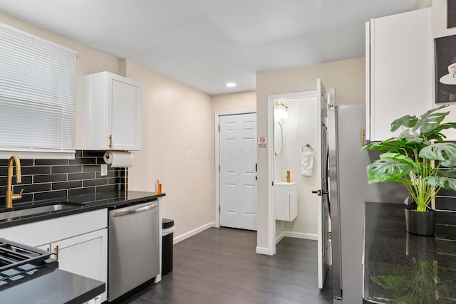 185 S Princeton Ave, Columbus, OH 43223 - kitchen with appliances with stainless steel finishes, dark countertops, dark wood finished floors, white cabinets, and tasteful backsplash