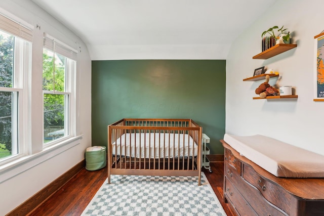 745 W Rich St, Columbus, OH 43222 - bedroom featuring wood finished floors, a nursery area, and an accent wall