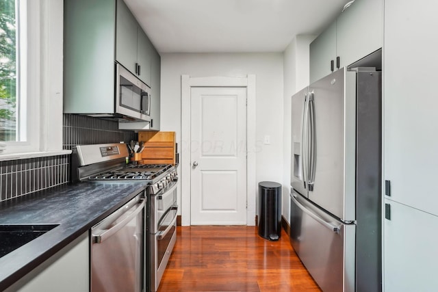 745 W Rich St, Columbus, OH 43222 - kitchen featuring appliances with stainless steel finishes, dark countertops, dark wood-style floors, and backsplash