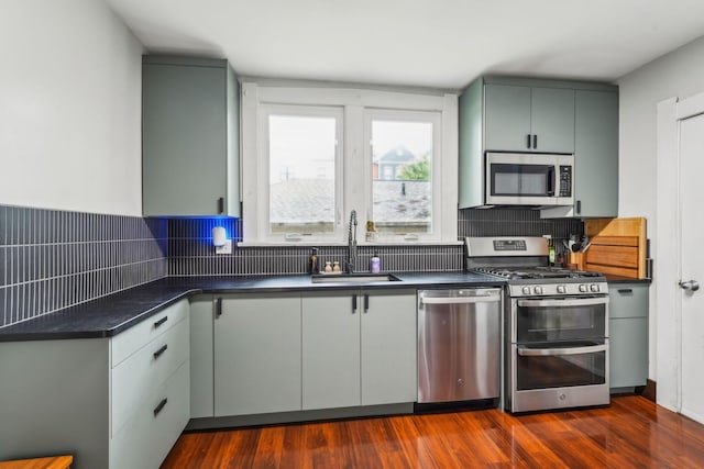 745 W Rich St, Columbus, OH 43222 - kitchen featuring appliances with stainless steel finishes, dark countertops, backsplash, and dark wood finished floors