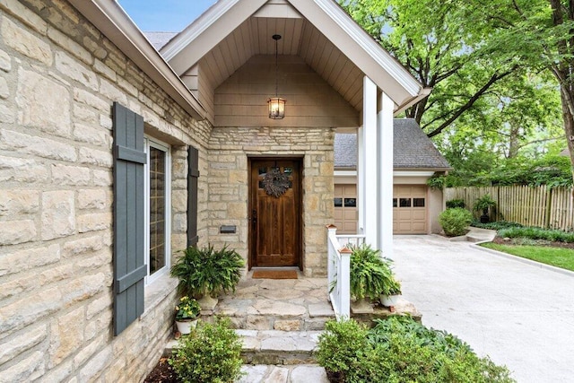 116 W Royal Forest Blvd, Columbus, OH 43214 - view of exterior entry with stone siding, concrete driveway, and an attached garage