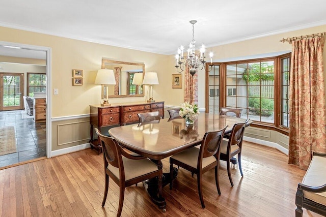 116 W Royal Forest Blvd, Columbus, OH 43214 - dining space with light wood-style flooring, a chandelier, a wainscoted wall, plenty of natural light, and crown molding