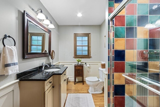 116 W Royal Forest Blvd, Columbus, OH 43214 - bathroom featuring wood finished floors, vanity, a wainscoted wall, a shower with door, and a decorative wall