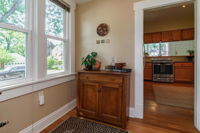 1734 W 1st Ave, Grandview, OH 43212 - detailed view of stainless steel gas range oven, brown cabinets, wood finished floors, and dark countertops