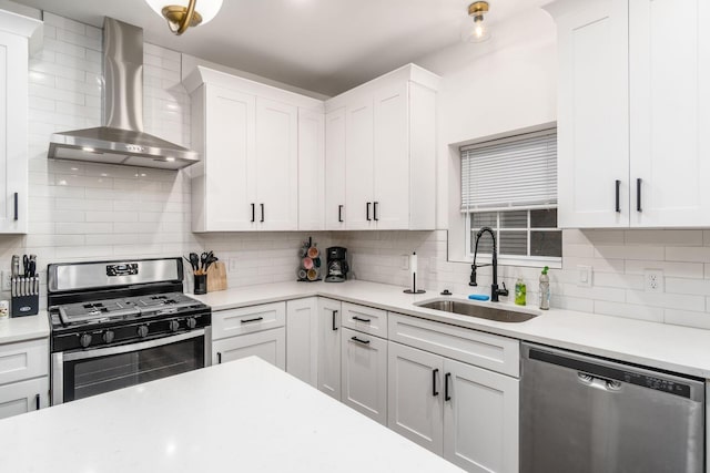 887-891 S 22nd St, Columbus, OH 43206 - kitchen with appliances with stainless steel finishes, wall chimney exhaust hood, light countertops, tasteful backsplash, and white cabinetry