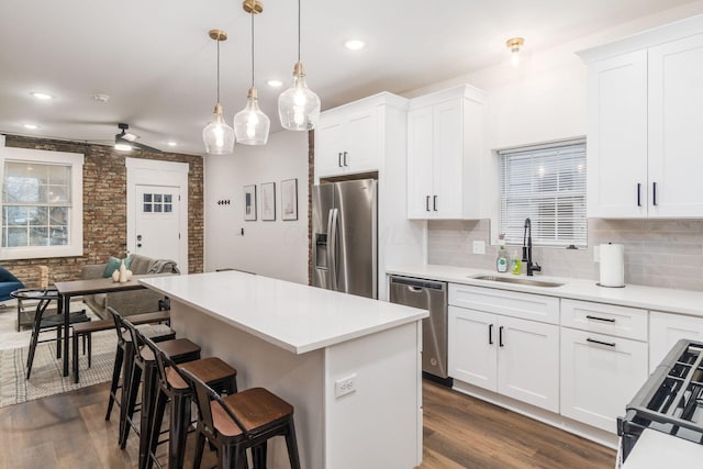 887-891 S 22nd St, Columbus, OH 43206 - kitchen featuring appliances with stainless steel finishes, a kitchen breakfast bar, a center island, backsplash, and dark wood-style flooring