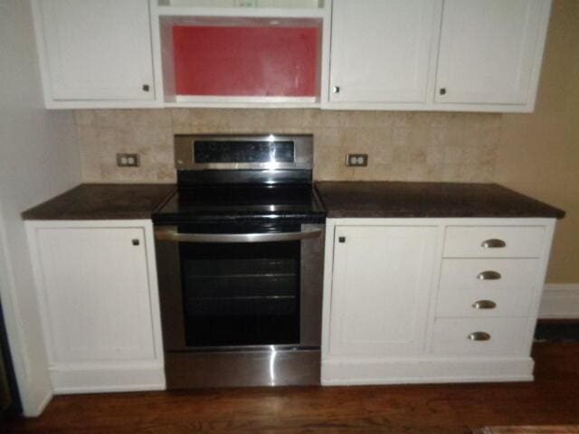312 W William St, Delaware, OH 43015 - kitchen with stainless steel electric range, dark countertops, white cabinetry, and backsplash