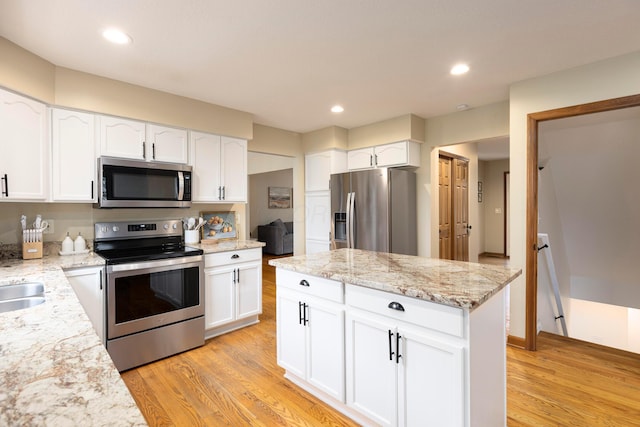 11578 Duncan Plains Rd NW, Johnstown, OH 43031 - kitchen with appliances with stainless steel finishes, light wood-style flooring, white cabinets, light stone countertops, and recessed lighting