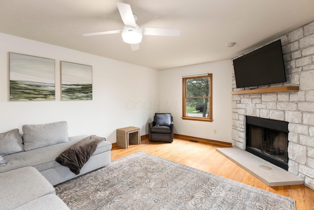 11578 Duncan Plains Rd NW, Johnstown, OH 43031 - living room with wood finished floors, a fireplace, and a ceiling fan