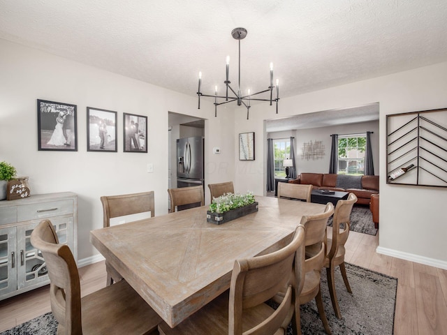 3552 Smiley Rd, Hilliard, OH 43026 - dining area with a chandelier, light wood-style floors, and a textured ceiling
