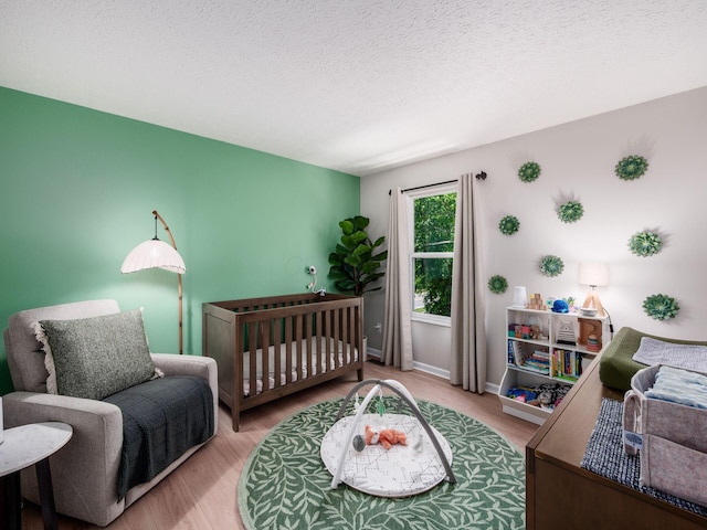 3552 Smiley Rd, Hilliard, OH 43026 - bedroom featuring wood finished floors, a textured ceiling, and a crib