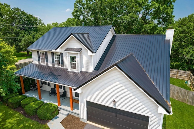 3552 Smiley Rd, Hilliard, OH 43026 - view of front of property featuring a metal roof, covered porch, a chimney, an attached garage, and driveway