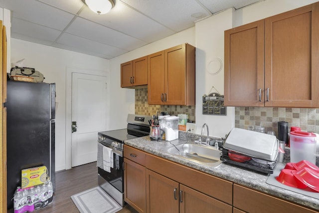 635-641 Racine Ave, Columbus, OH 43204 - kitchen featuring stainless steel appliances, a paneled ceiling, brown cabinetry, dark wood finished floors, and tasteful backsplash