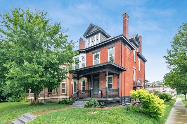 572 Linwood Ave, Columbus, OH 43205 - traditional style home featuring covered porch, a chimney, a front lawn, and brick siding
