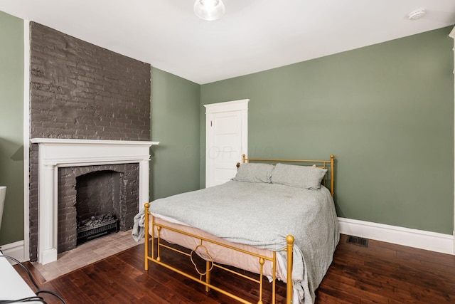 572 Linwood Ave, Columbus, OH 43205 - bedroom with hardwood / wood-style flooring and a brick fireplace