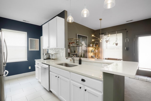 5928 Treven Way, Westerville, OH 43081 - kitchen featuring appliances with stainless steel finishes, a peninsula, white cabinetry, decorative backsplash, and decorative light fixtures