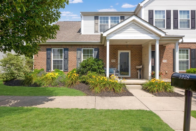 5928 Treven Way, Westerville, OH 43081 - view of front of property with brick siding, covered porch, roof with shingles, and a front lawn