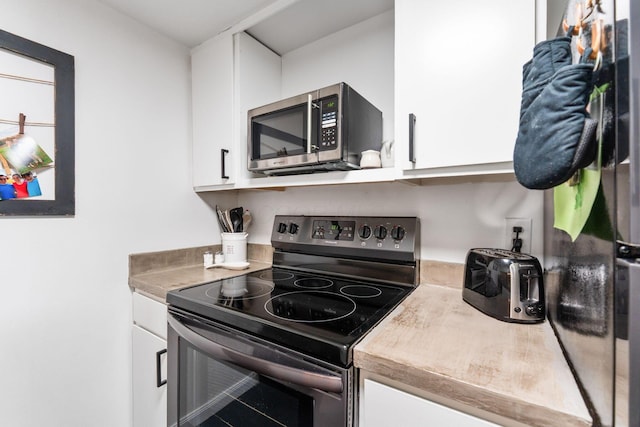1080 Merrimar Cir S Unit E, Columbus, OH 43220 - kitchen with range with electric cooktop, stainless steel microwave, white cabinets, and light countertops
