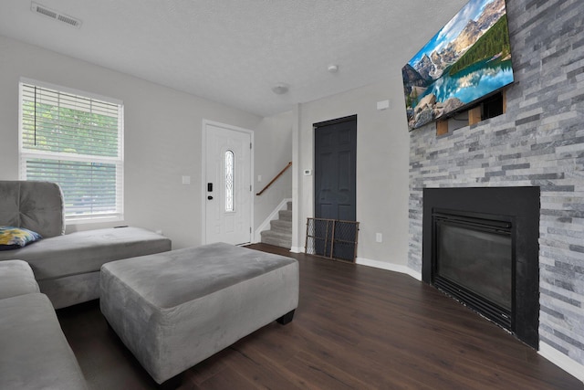4686 Willowburn Dr, Columbus, OH 43207 - living area featuring dark wood finished floors, stairs, a fireplace, and a textured ceiling